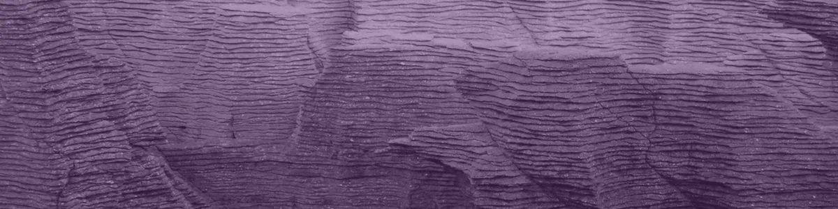 Tinted detail of a photo: Weathered limestone cliff built of hundreds of thin stacked layers like a pile of pancakes, grey at the top and orange-brown below, with a small dark pool in a hollow.