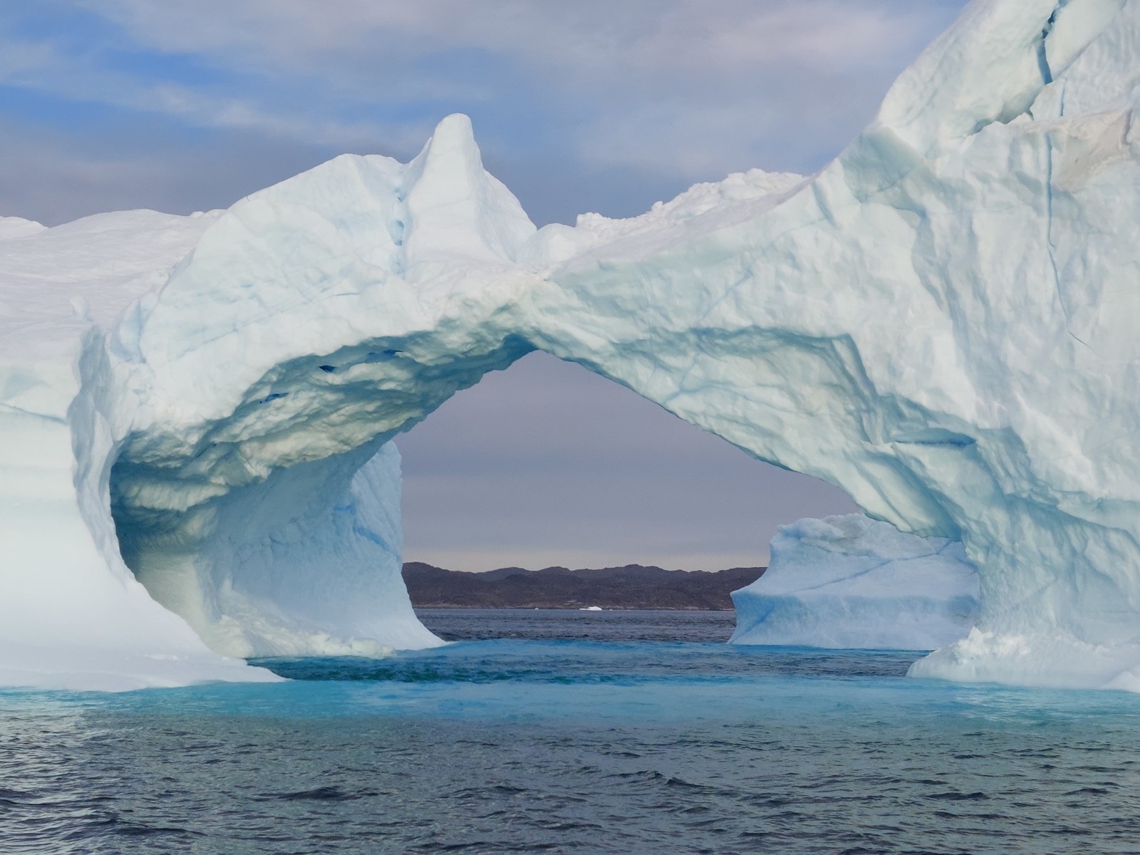 Iceberg arch over the sea.