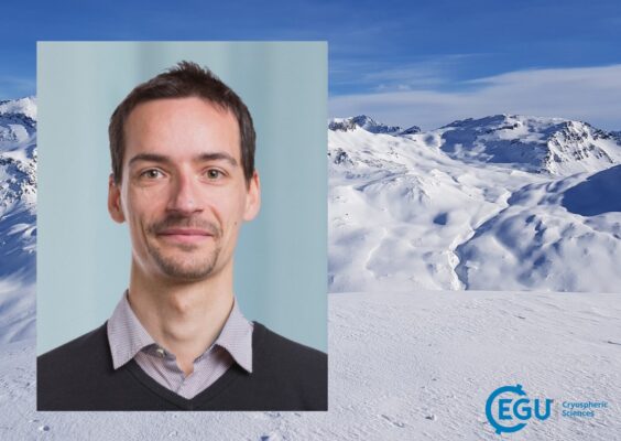 A profile image of a white man with beard, shirt and pullover in front of a glacier landscape.