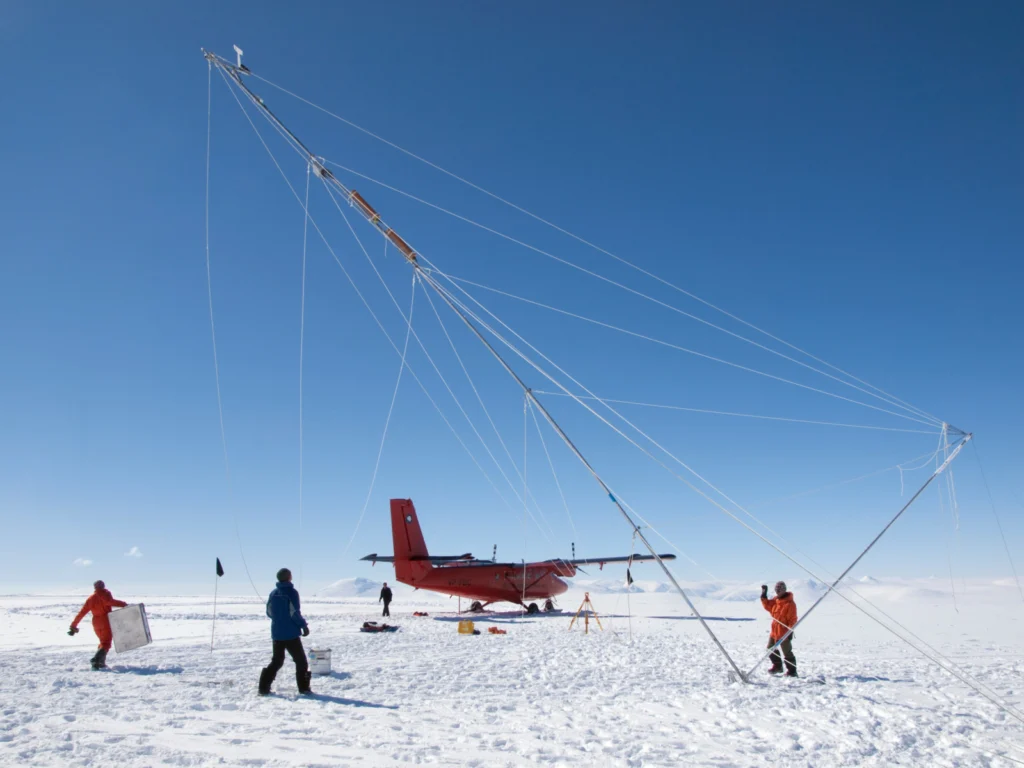 A plane and several researchers on the ice in Antarctica.