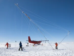 A plane and several researchers on the ice in Antarctica.