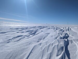 Wavy ice feature in front of wide blue sky.