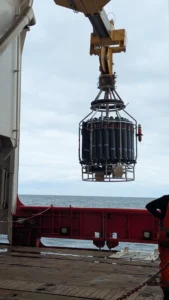 washing-machine sized intrument is lowered into ocean from deck of ship