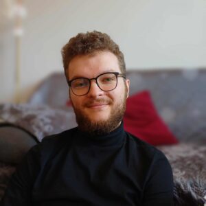 Portrait photograph of Maciej smiling at the camera