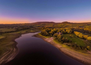 An oblique aerial photograph of the river Trent at dusk/dawn (a dark blue sky with orange along the horizon). 