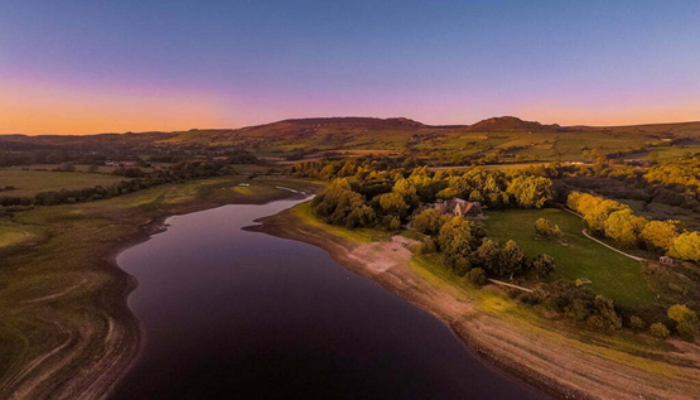 An oblique aerial photograph of the river Trent at dusk/dawn (a dark blue sky with orange along the horizon).