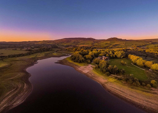 An oblique aerial photograph of the river Trent at dusk/dawn (a dark blue sky with orange along the horizon).