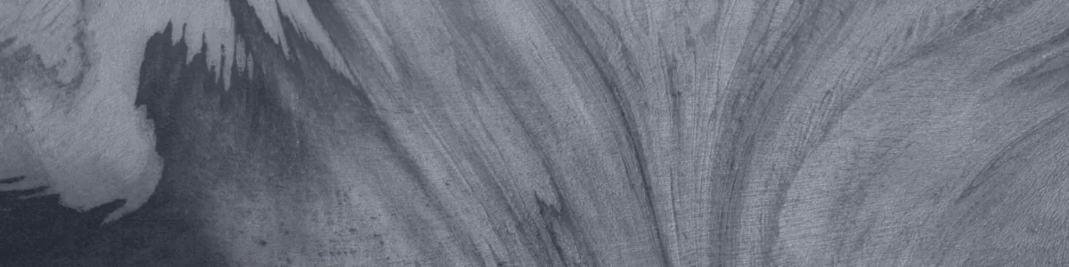 Tinted detail of a photo: Aerial view of a glacier surface in pale blue and white, its ice streaked with dark curving bands that sweep and swirl like marbled paper, with a deep blue shadowed area at lower left.