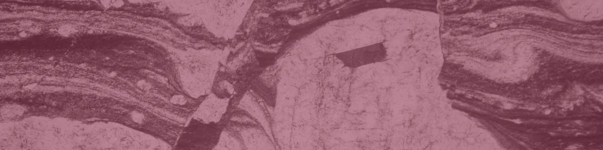 Tinted detail of a photo: Thin-section micrograph of a pale, rounded feldspar grain wrapped in curving dark and light bands of fine-grained rock, cut and slightly offset by straight diagonal cracks.