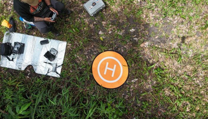 This image shows a drone operator guiding a drone to its landing spot.