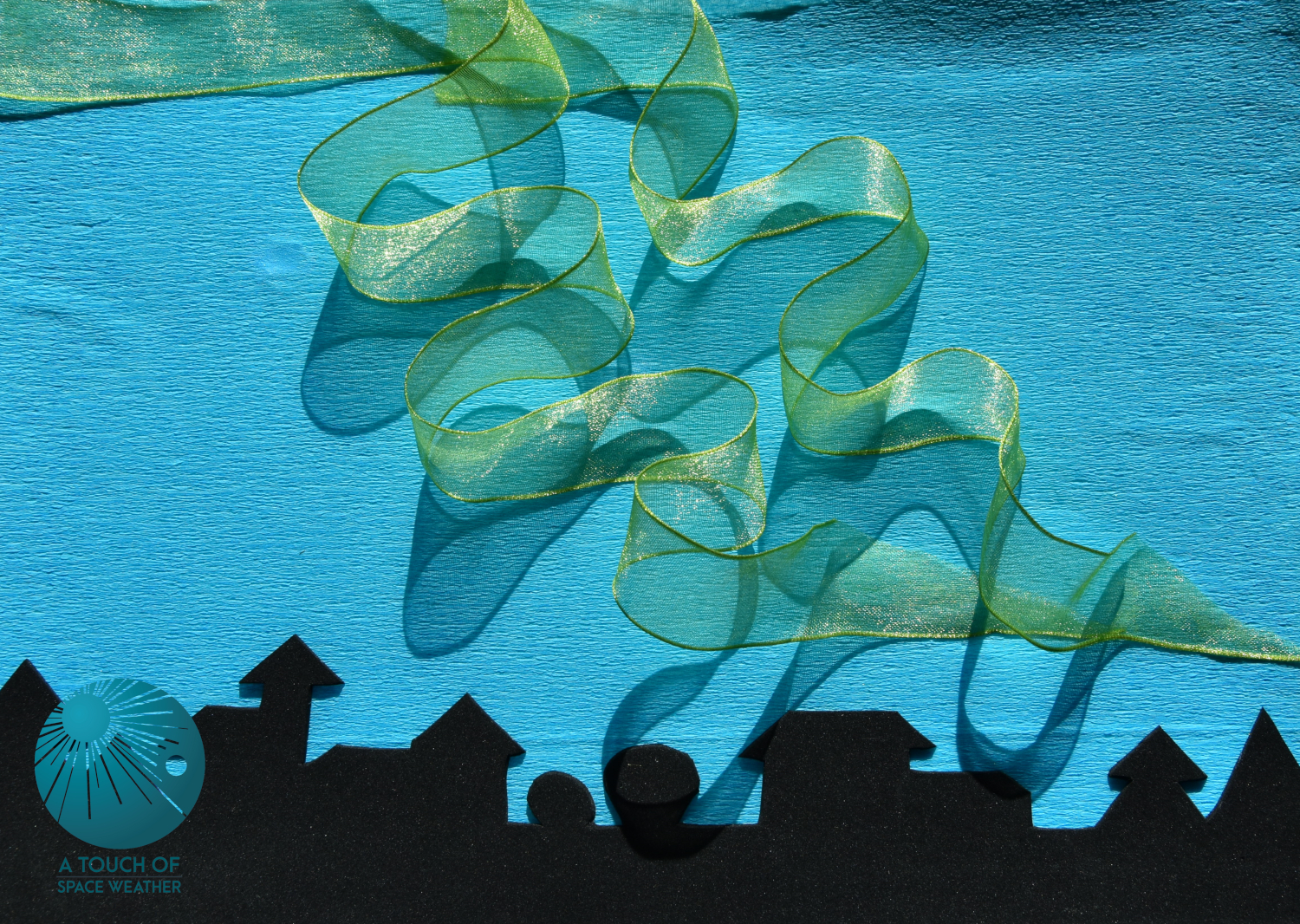 Soft waving yellow/green mesh ribbon on a blue background with a black silhouetted skyline at the base.