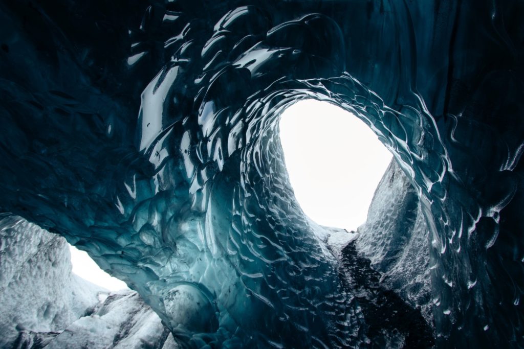 Light shining through ice inside of a glacier by Alexandra von der Esch