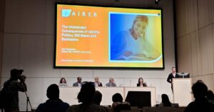 The image shows panelists during the Great Debate "What's next for EDI in these turbulent times? " at EGU26. From left to right: Marguerite Xenopoulos (Trent University), Brandon Jones (American Geophysical Union), Yukihiro Takahashi (Hokkaido University), Alberto Montanari (University of Bologna) and Convener Claudia Jesus-Rydin. Panelist Dan Robertson from Fairer Consulting is speaking on the podium. 