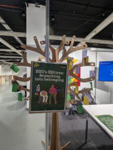The image shows a cardboard tree with hanging notes, each contaning a different message about EDI.