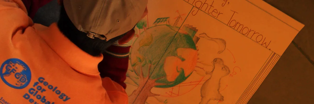 A person in a Geology for Global Development hoodie looking at a drawing of the Earth