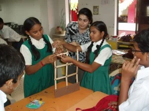 Solmaz during a public engagement activity at a school in Gujarat, India. School children are tought to build and test a wall model on a shake table as part of a  earthquake education workshop.  Image courtesy of Solmaz Mohadjer.