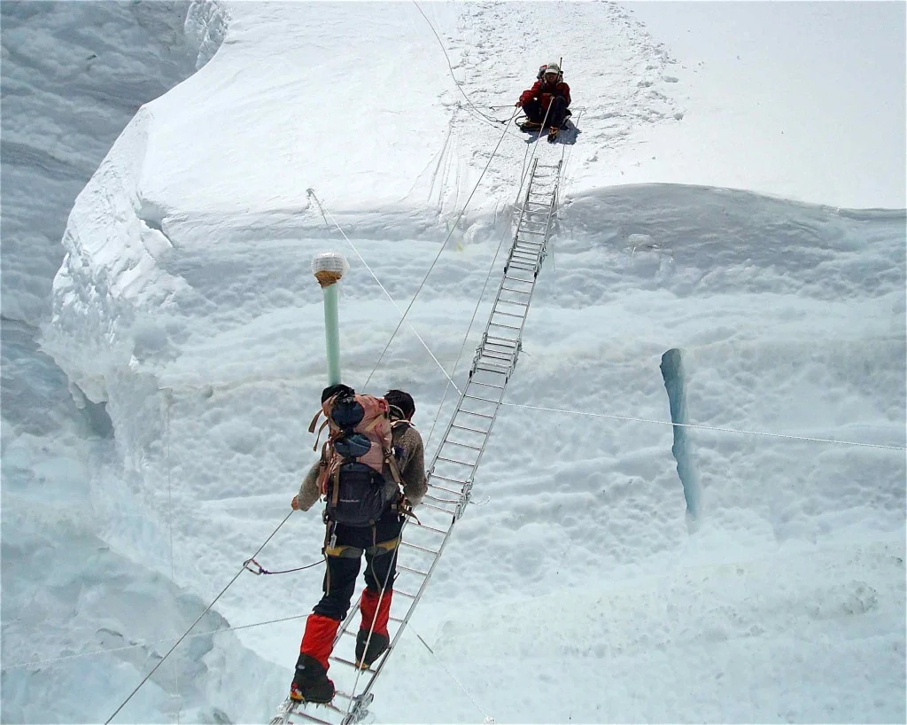Pemba Wangchu traversing a ladder in the Khumbu Icefall, while Pema Sherpa had crossed safely. They were part of an expedition team to install a weather station at the South Col at 8,000 metres above sea level. (Credit: SHARE Everest Expedition)