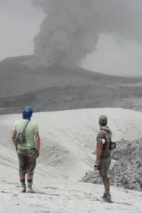 Ian Schipper with Jon Castro watching the mouth of the volcano churning out volcanic ash. Image Credit: Dr. Hugh Tuffen