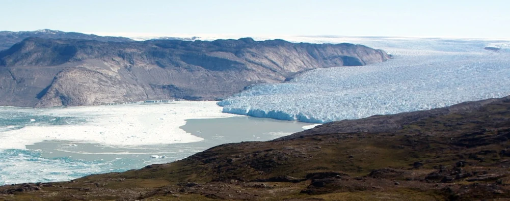 Figure 2: Kangiata Nunata Sermia, a large tidewater glacier in south-west Greenland. The expression of a plume originating at the base of the calving front is visible on the fjord surface as turbid sediment-rich water. [Credit: Peter Nienow]