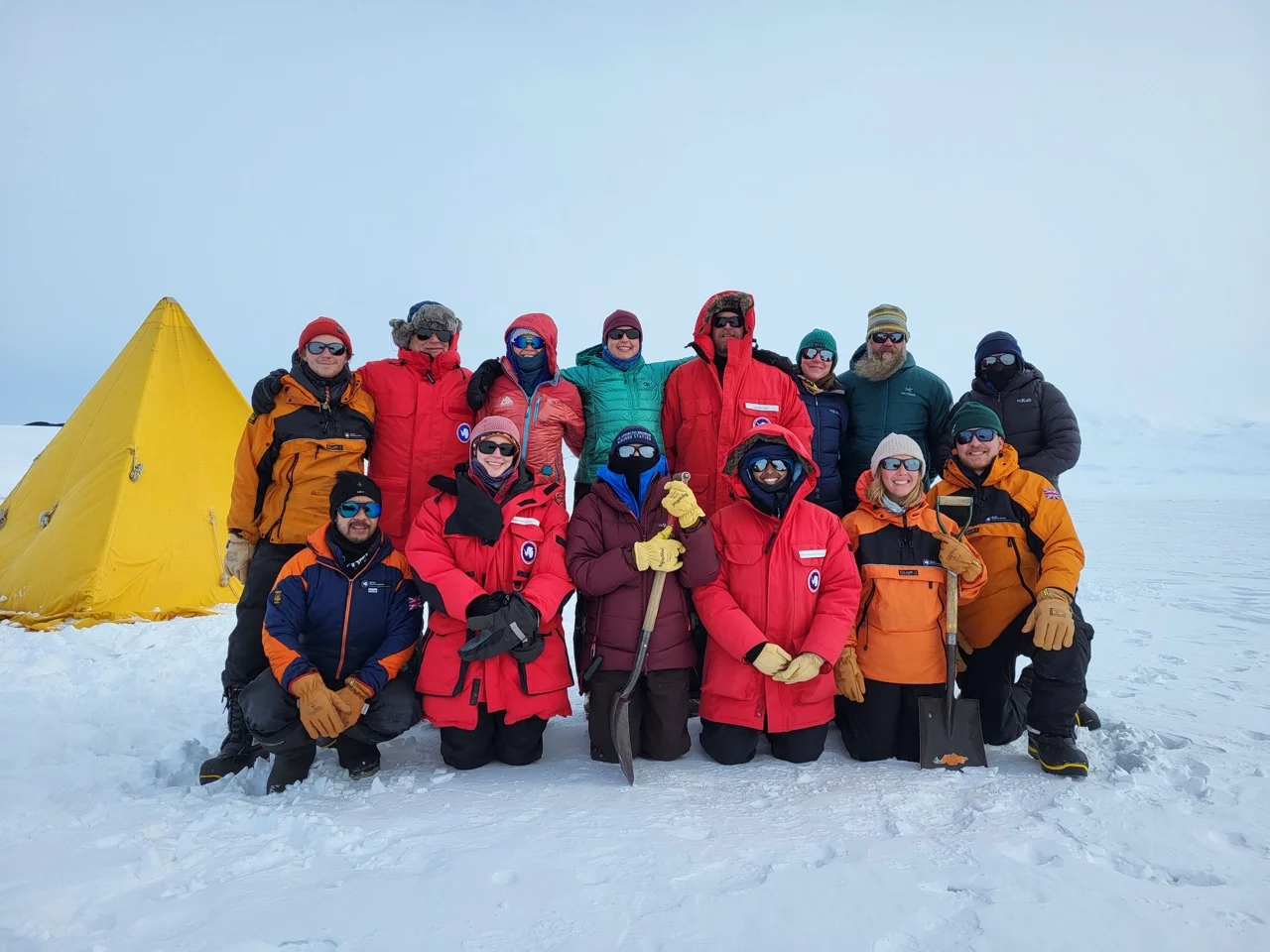 A group of colourfully and warm dressed people on the snow.