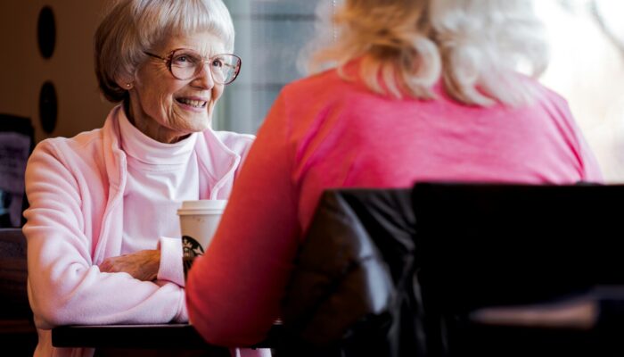 A conversation between a person and a smiling elder lady.