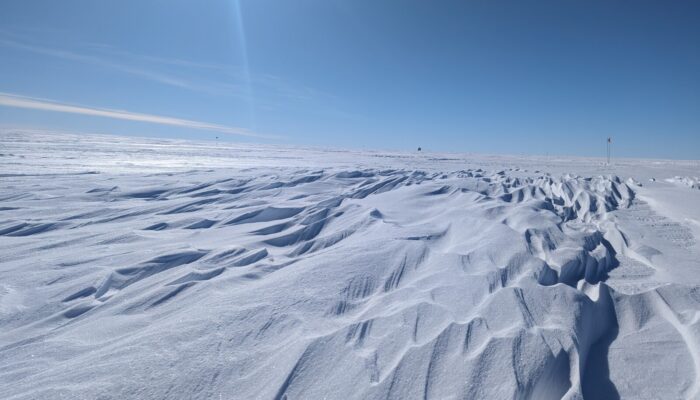 Wavy ice feature in front of wide blue sky.