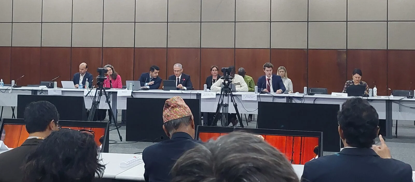 a board of 6 individuals with cameras and media filming them whilst they answer questions from the public. 