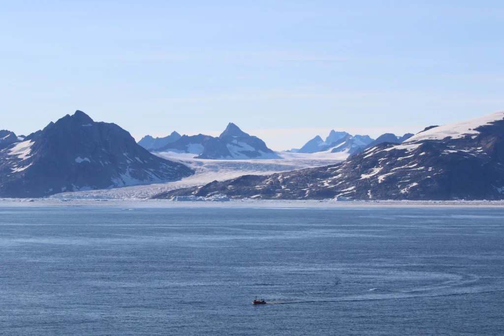 mountainous coast with a glacier cutting through the center, opening to ocean