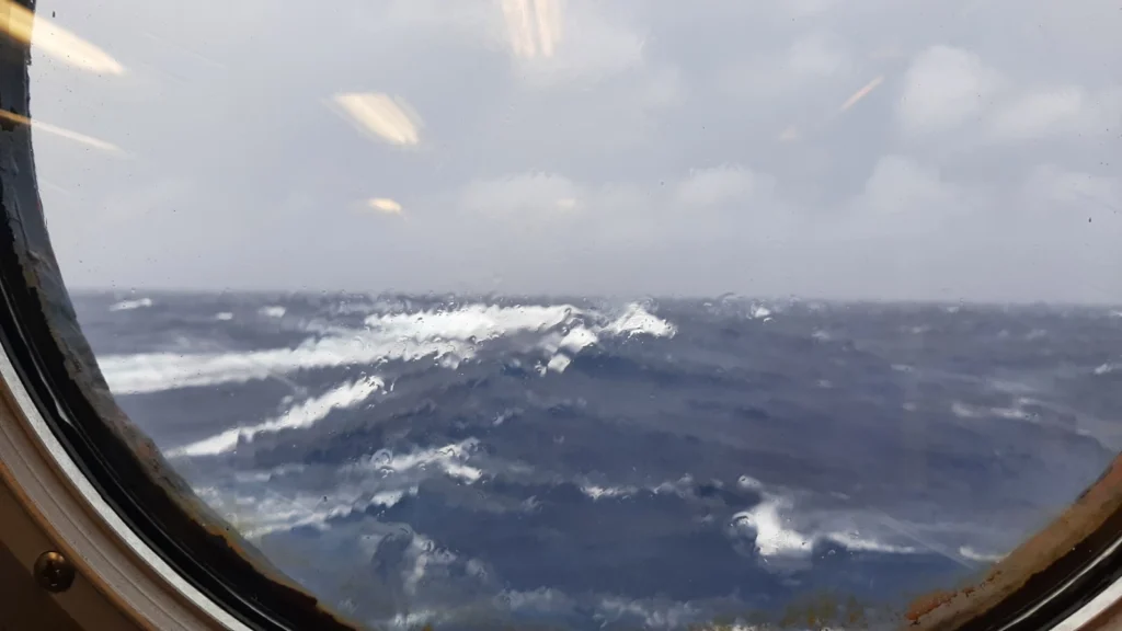 Photo of a stormy sea through the porthole of a ship