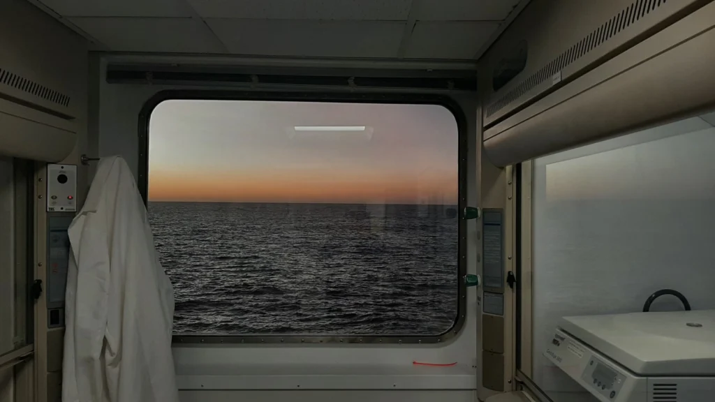 Photo of a pre dawn horizon taken through a window on a ship