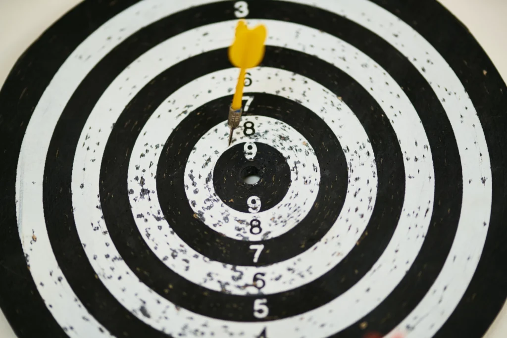 Black and white aim with a yellow dart arrow.