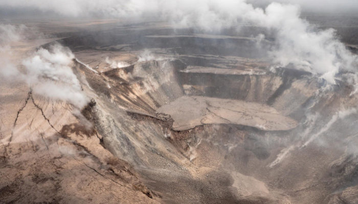 Photograph of Kīlauea’s summit, Halema’uma’u Crater, partway through the 2018 eruption. The seismic events at the summit and associated eruptive activity greatly changed the structure of the summit and surrounding region. Photograph by Hawaiian Volcano Observatory on June 12, 2018 (https://www.usgs.gov/media/images/k-lauea-volcano-halema-uma-u-crater-0).